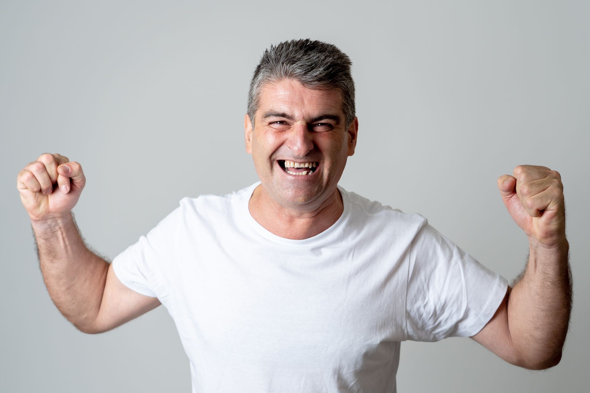 Man rejoices in achieving his goal, wining the lottery or having great success in face expression human emotions surprised and happy facial expression isolated on grey background.
