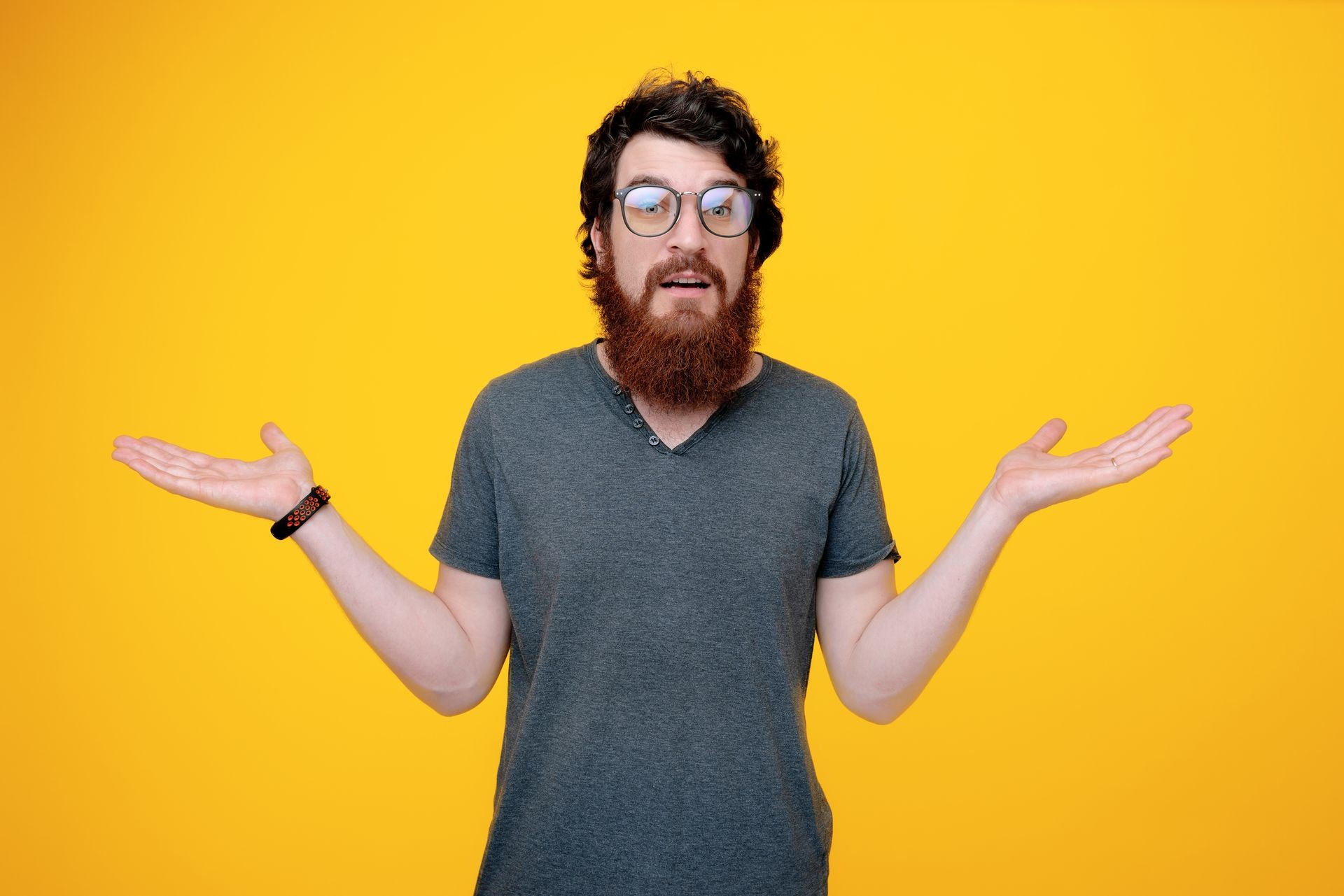 Photo of bearded guy in glases, doing unknown gesture with rised hands and looking at camera 